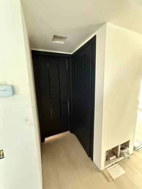 Two LV-04 doors installed side by side in a hallway - bold black against white walls