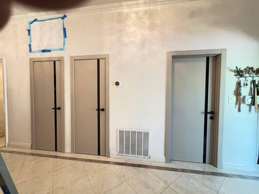 Three YL-G doors in a row - beige finish with black glass inserts and matte black handles