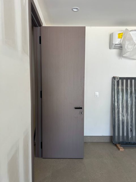 YL-F door in greige finish with modern hardware and concrete-style flooring