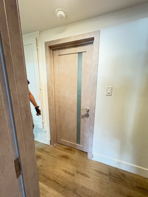 LV-21 beige concrete swing door installed in a modern residential hallway